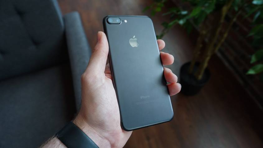 Hand holding a black smartphone, illustrating a digital arrest scam call