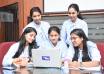 Young Indian interns working on laptops in an office