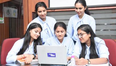 Young Indian interns working on laptops in an office