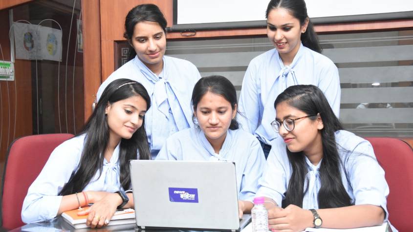 Young Indian interns working on laptops in an office