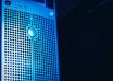 Rows of server racks with blue lights inside a modern AI data centre