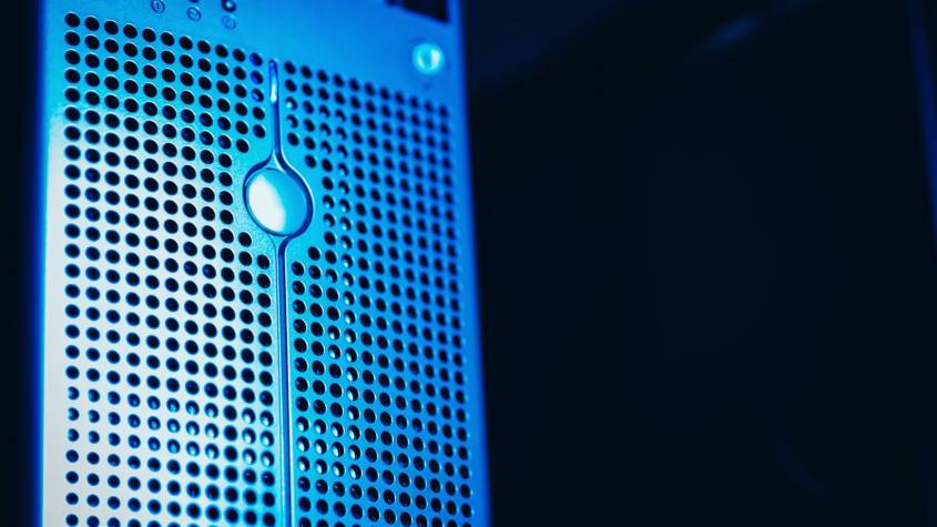 Rows of server racks with blue lights inside a modern AI data centre